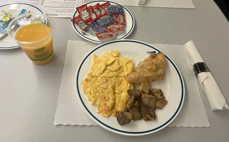 食堂車の朝食。スクランブルエッグとポテト、クロワッサン