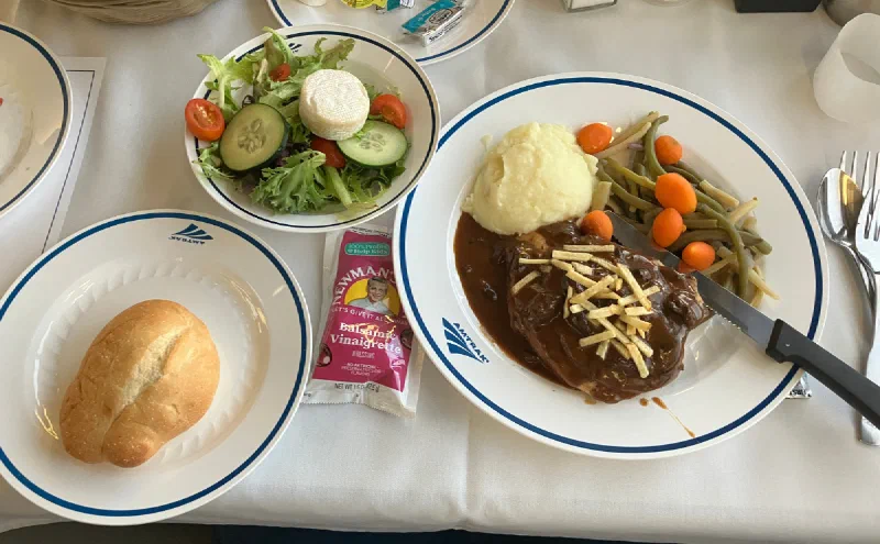 サラダとパンが付いた食堂車のステーキ