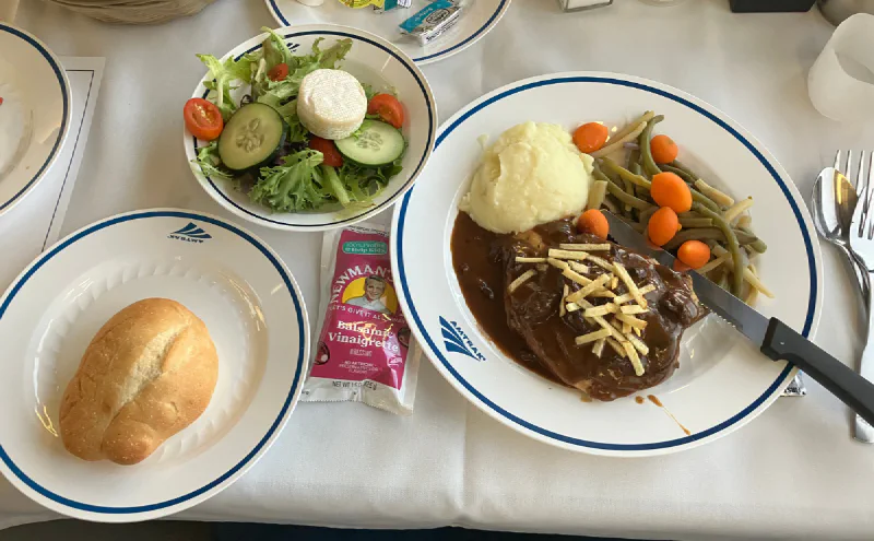 サラダとパンが付いた食堂車のステーキ