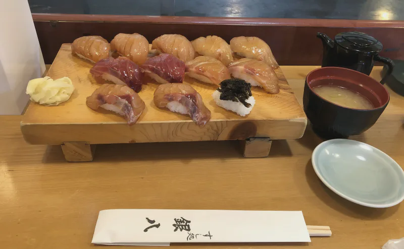 すし処「銀八」の島寿司。白身魚のづけの握りが板に並ぶ