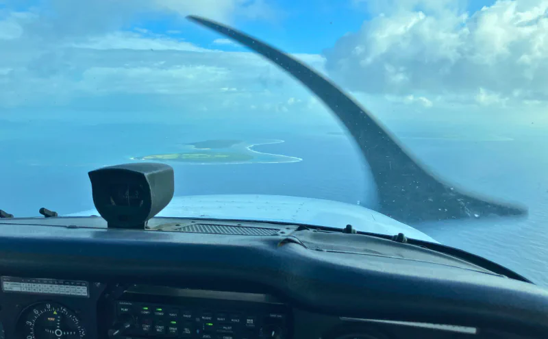セスナの機内から見た主翼と海