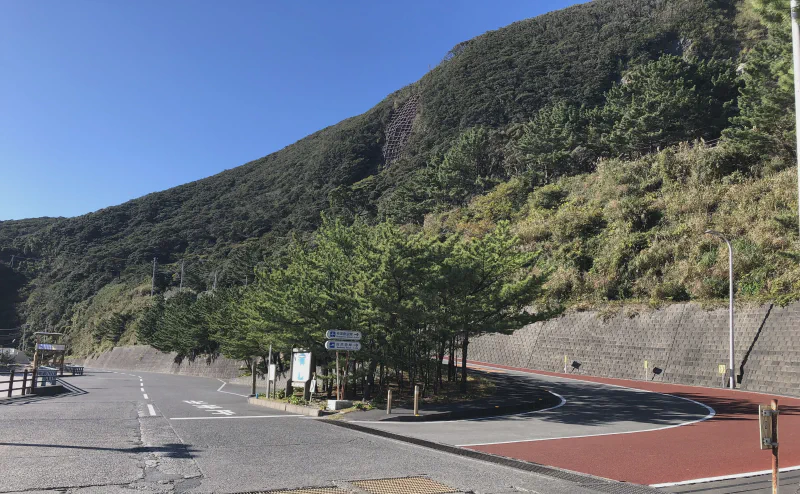 神津島の港へ向かう道路。背後に島の山が迫る
